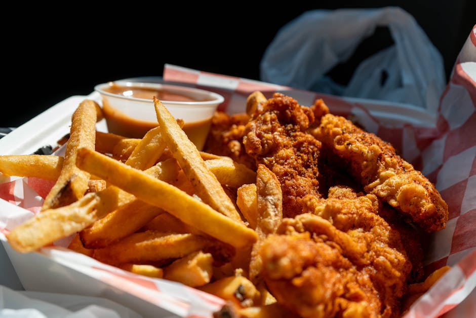 Delicious serving of crispy fried chicken with fries and dipping sauce in Holland, Michigan.