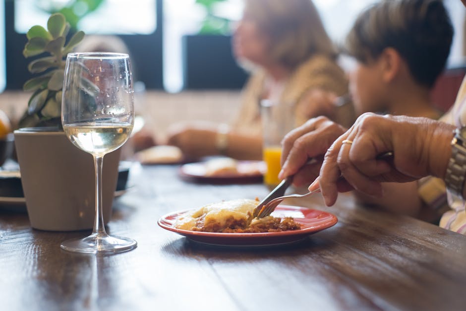 A close-up of a dining scene in Portugal with wine and a meal, highlighting a social atmosphere