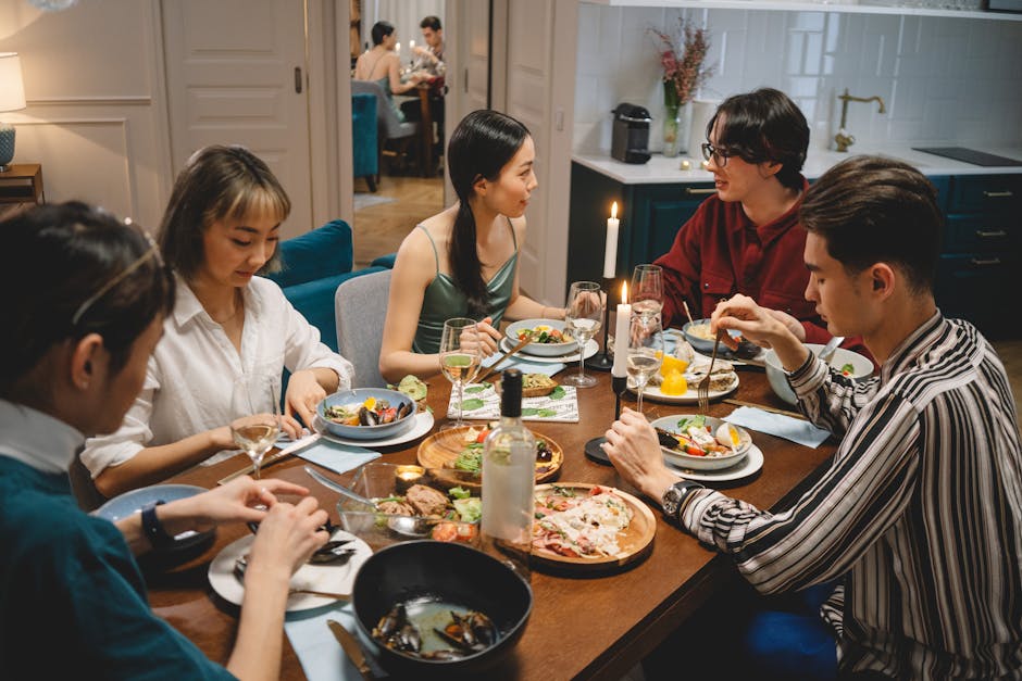 A diverse group of friends sharing dinner at a cozy dining table with wine and lighted candles